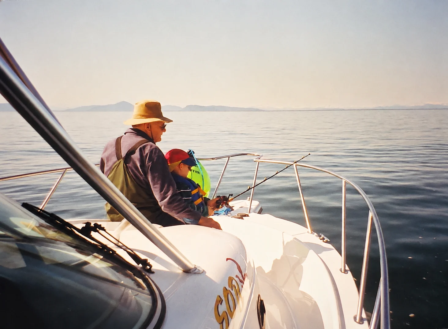 Thomas as a child fishing beside his grandfather on a boat in Valdez, Alaska
